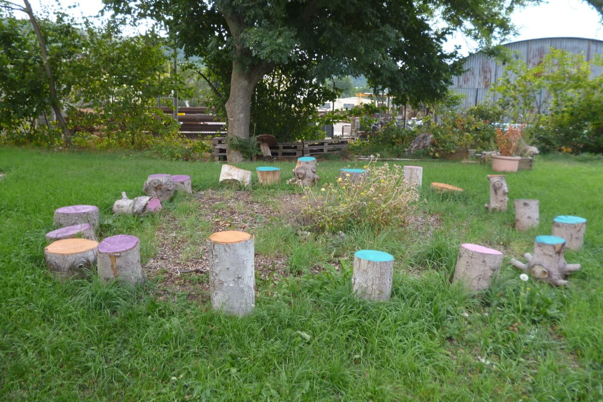 Schulgarten mit Sitzgelegenheiten aus Baumstümpfen
