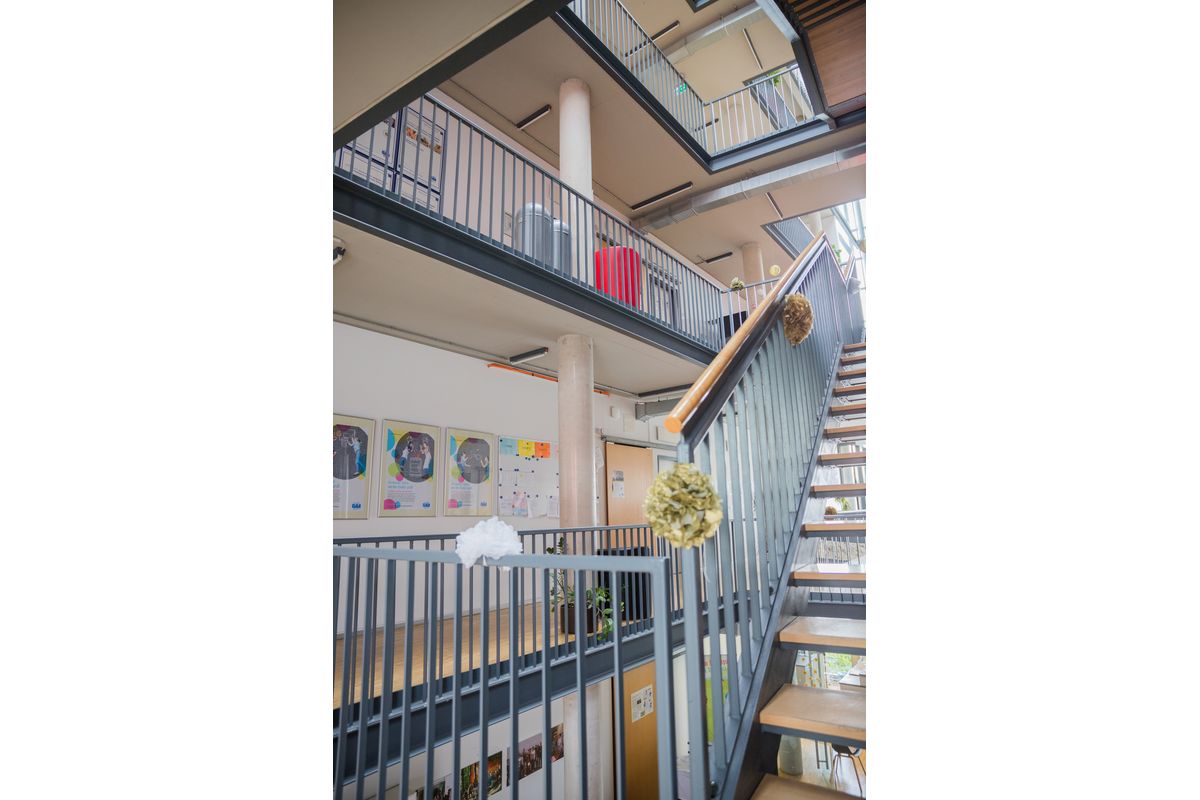 Das Bild zeigt eine weitere Innenansicht des Schulgebäudes der DAA Fachschule für Sozialpädagogik Aalen. Zu sehen sind das Treppenhaus, sowie die Zugänge zu den Unterrichtsräumen über zwei Stockwerke.